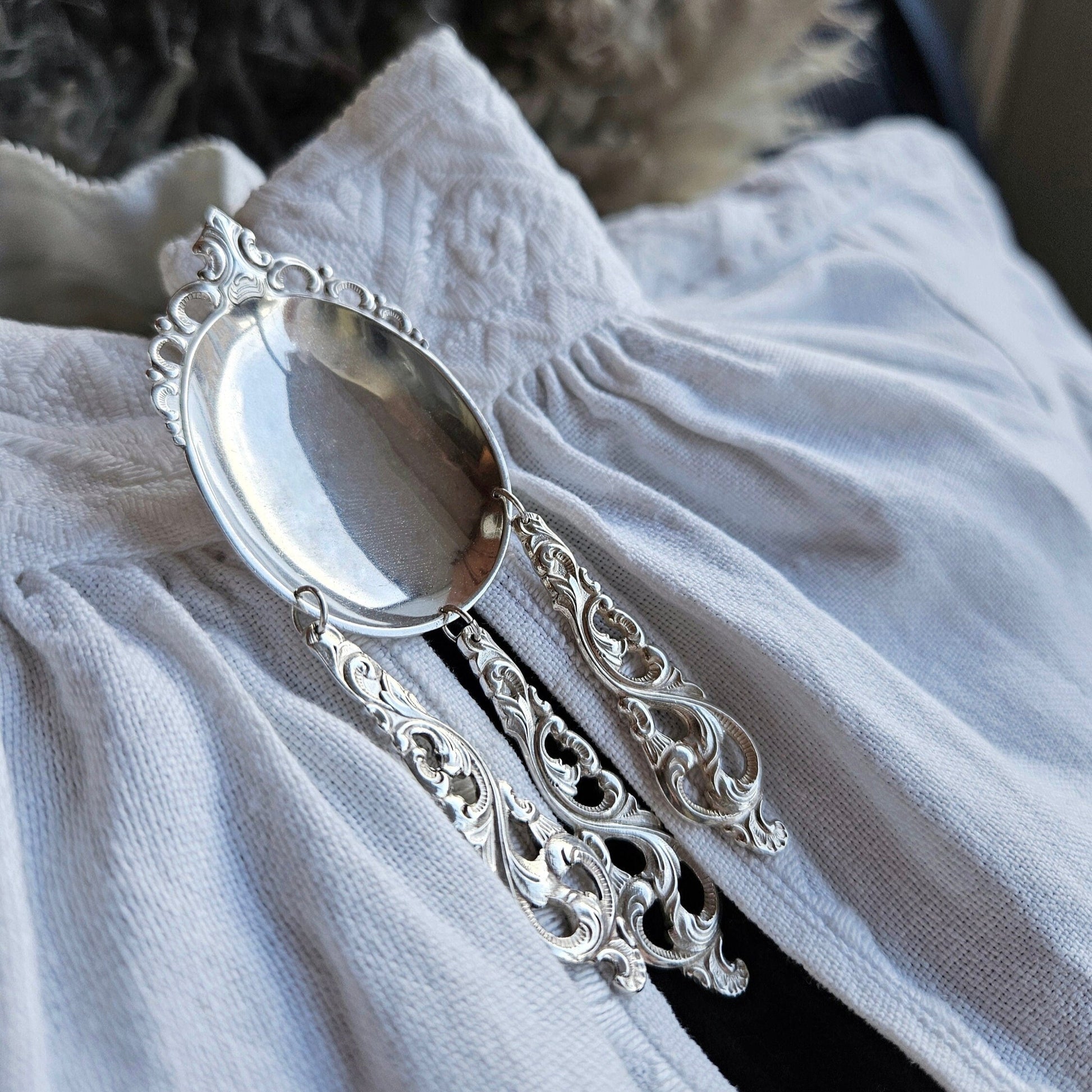 Sølje 1:
Sølje fra sølvskjeer mønster Dobbel Rokokko.
Ca 4 cm bred x 11 cm høy.